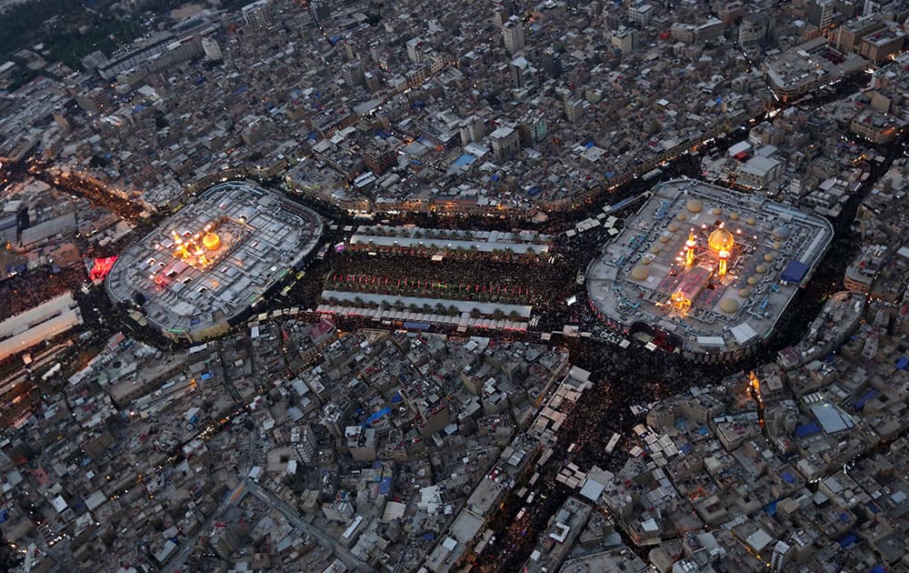 This aerial photo shows Shiite faithful pilgrims gather between, the holy shrine of Imam Hussein and the holy shrine of Imam Abbas, right, for Arbaeen in the Shiite holy city of Karbala, 50 miles (80 kilometers) south of Baghdad, Iraq.