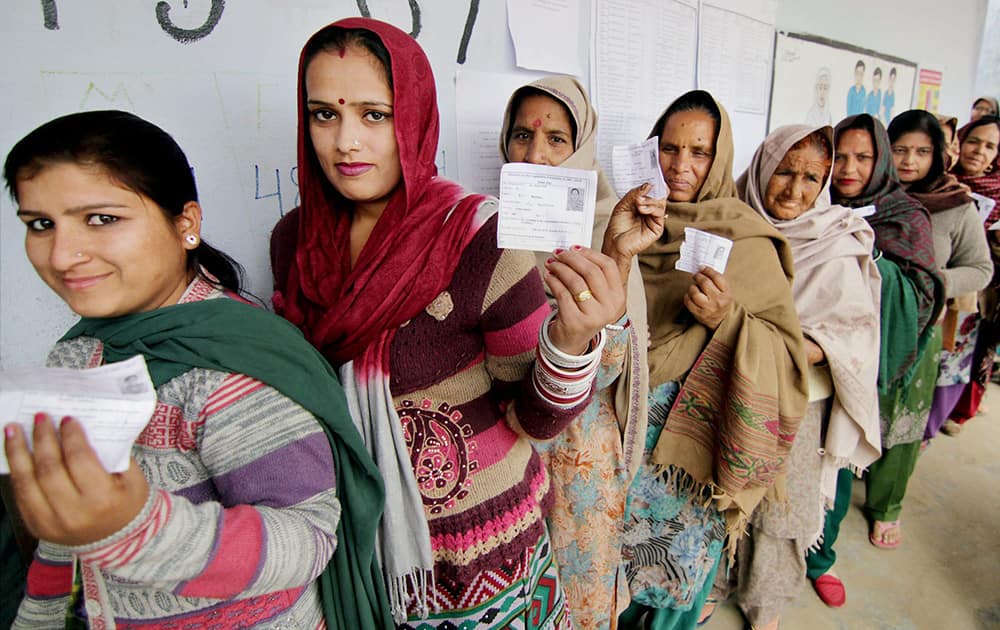 Women voters show their voter ID cards as they stand in queue to cast their votes during the 4th Phase of J&K Assembly Election at a polling station in Vijaypur in Jammu.