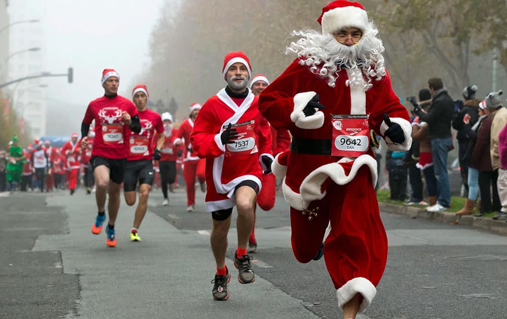 Runners, dressed as Santa Claus, take part in the 38th Christmas Corrida Race in the streets of Issy Les Moulineaux, on the western outskirts of Paris.
