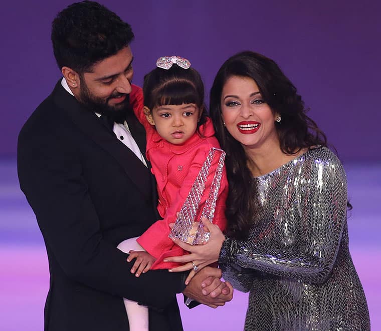 Former Miss World Aishwarya Rai, right speaks on stage with husband Abhishek Bachchan and daughter Aaradha, during the Miss World 2014 final, on stage at the Excel centre in east London.