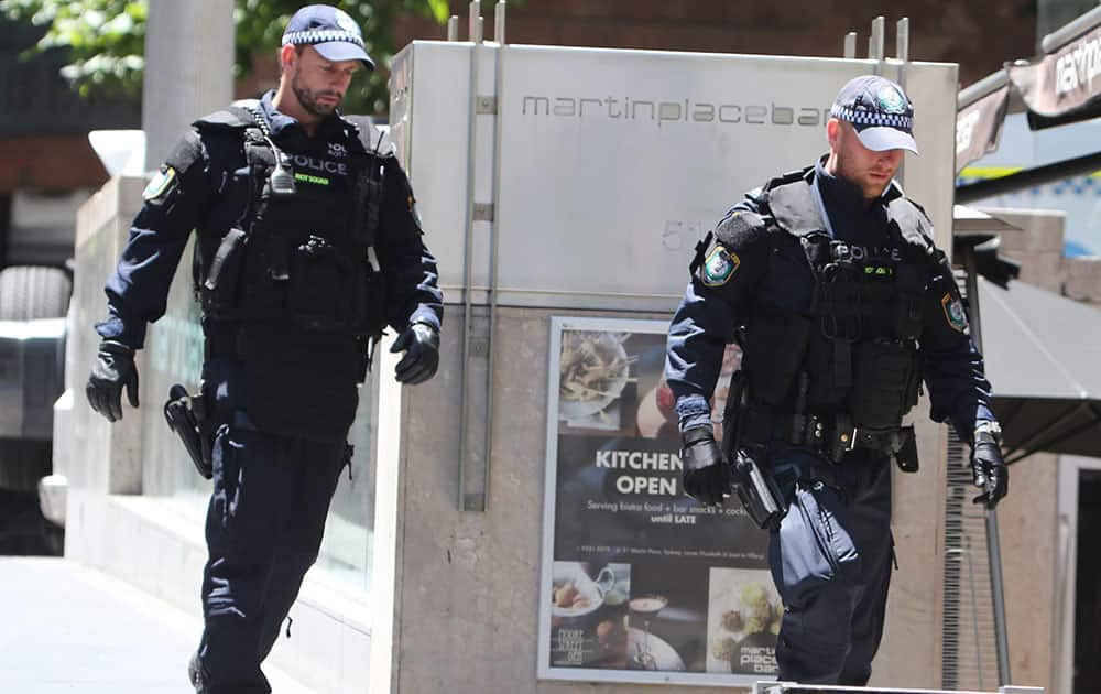 Police check buildings close to a cafe under siege at Martin Place in the central business district of Sydney, Australia.