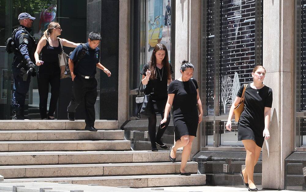 Police evacuate people from an office building close to a cafe under siege at Martin Place in the central business district of Sydney, Australia.