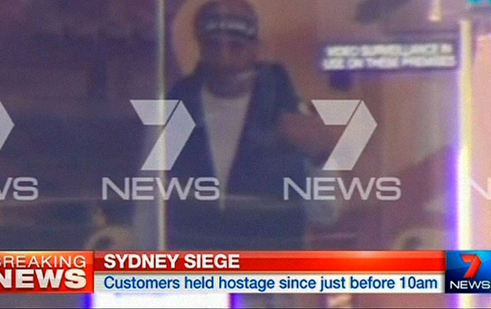 This image taken from video shows a man believed to be a gunman inside a cafe in Sydney, Australia.