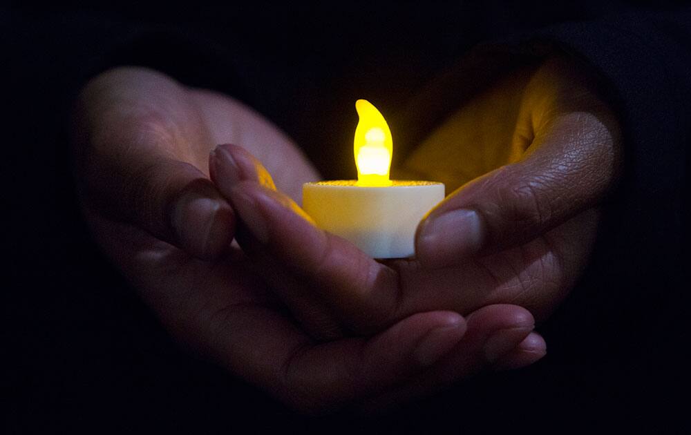 Mary Lawson holds a candle during a protest against oppression and injustice, honoring Michael Brown and Eric Garner, in downtown Lincoln, Neb.