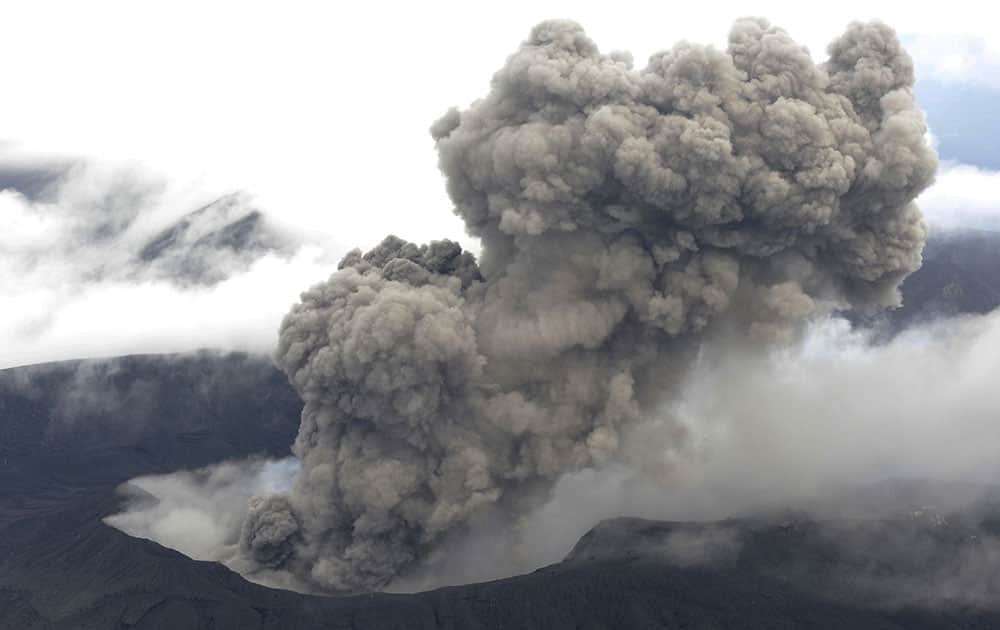 In this Nov. 26, 2014 photo, volcanic smoke billows from Mount Aso, Kumamoto prefecture, on the southern Japanese main island of Kyushu. The volcano is blasting out chunks of magma in the first such eruption in 22 years, causing flight cancellations and prompting warnings to stay away from its crater. 