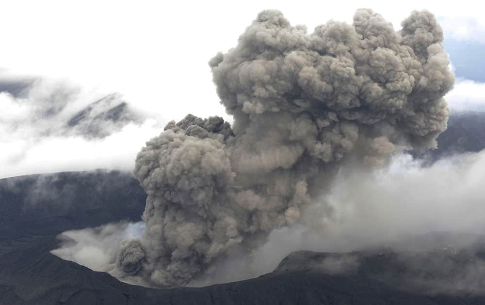 In this Nov. 26, 2014 photo, volcanic smoke billows from Mount Aso, Kumamoto prefecture, on the southern Japanese main island of Kyushu. The volcano is blasting out chunks of magma in the first such eruption in 22 years, causing flight cancellations and prompting warnings to stay away from its crater.