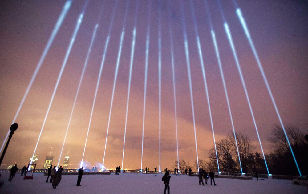 Fourteen lights shine toward the sky during a ceremony on Mount Royal to mark the 25th anniversary of the Polytechnique massacre Saturday, Dec. 6, 2014 in Montreal.
