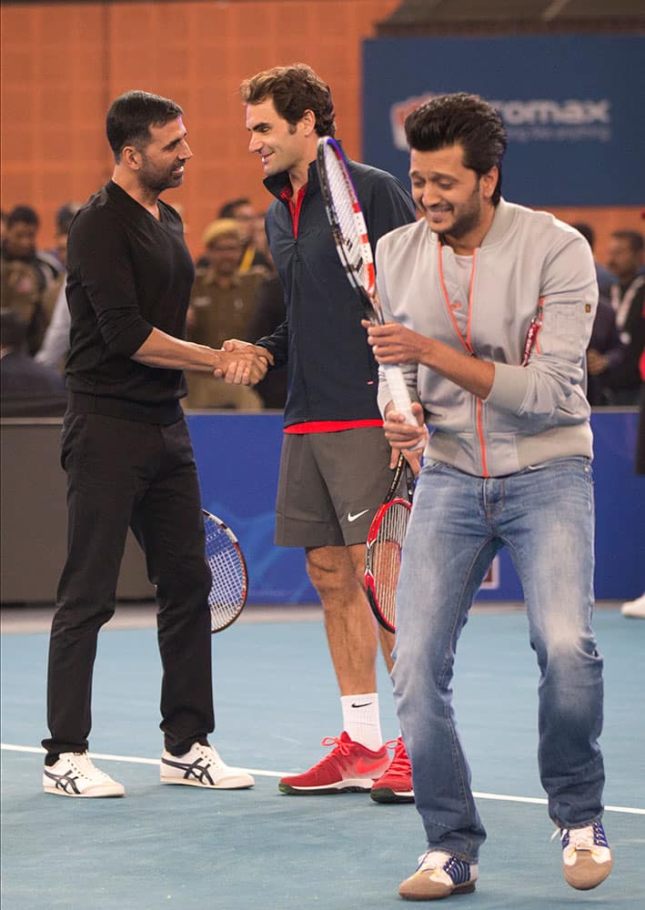 Micromax Indian Aces player Roger Federer, shakes hands with Indian Bollywood actor Akshay Kumar, left, as actor Ritesh Deshmukh passes by during a match on the sidelines of the International Premier Tennis League, in New Delhi, India.