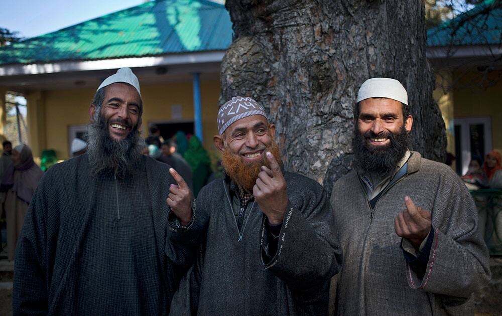 Kashmiri Muslim men show the ink mark on their index fingers after casting their votes during the third phase polling of the Jammu and Kashmir state elections in Monu, about 25 kilometers (15 miles) south west of Srinagar, India, Tuesday, Dec. 9, 2014. 