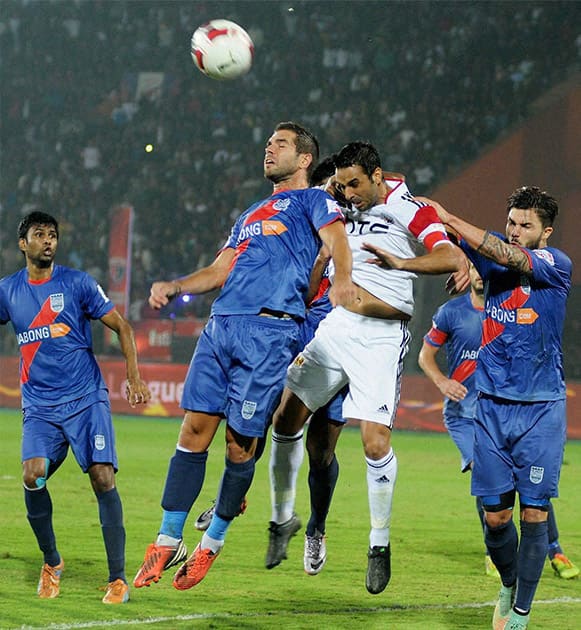 Players of North East United FC (in white jersey) and Mumbai City FC (in blue jersey) in action during their ISL match at Indira Gandhi Stadium in Guwahati.