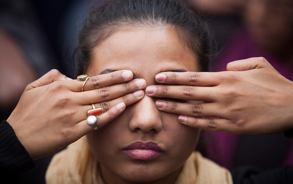 A girl participates in a street play to create awareness on violence against women during a protest ahead of the second anniversary of the deadly gang rape of a 23-year-old physiotherapy student on a bus, in New Delhi.