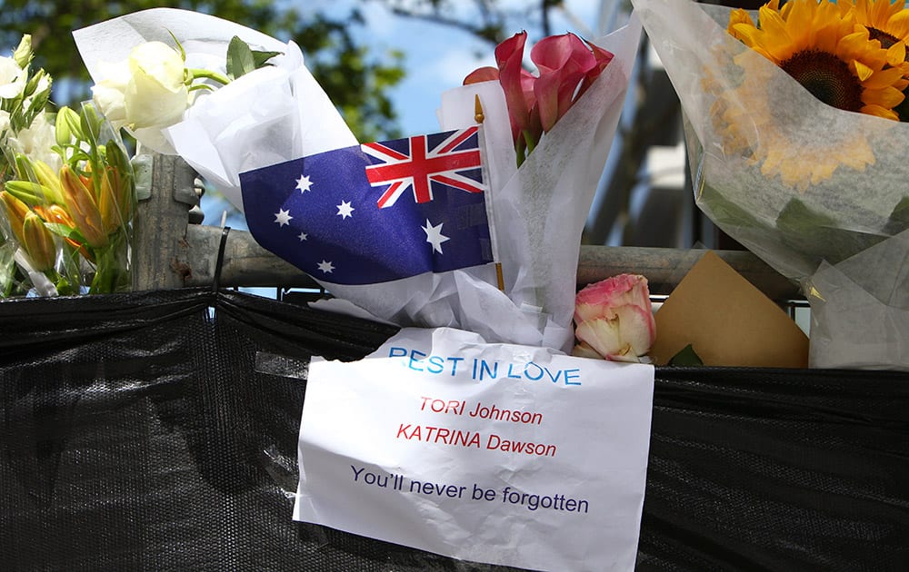 Flowers are placed on a fence in a makeshift memorial near the site where a gunman held hostages for 16 hours at a popular Sydney cafe.