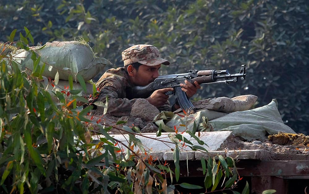A Pakistani army soldier takes position on a bunker close to a school under attack by Taliban gunmen in Peshawar, Pakistan.