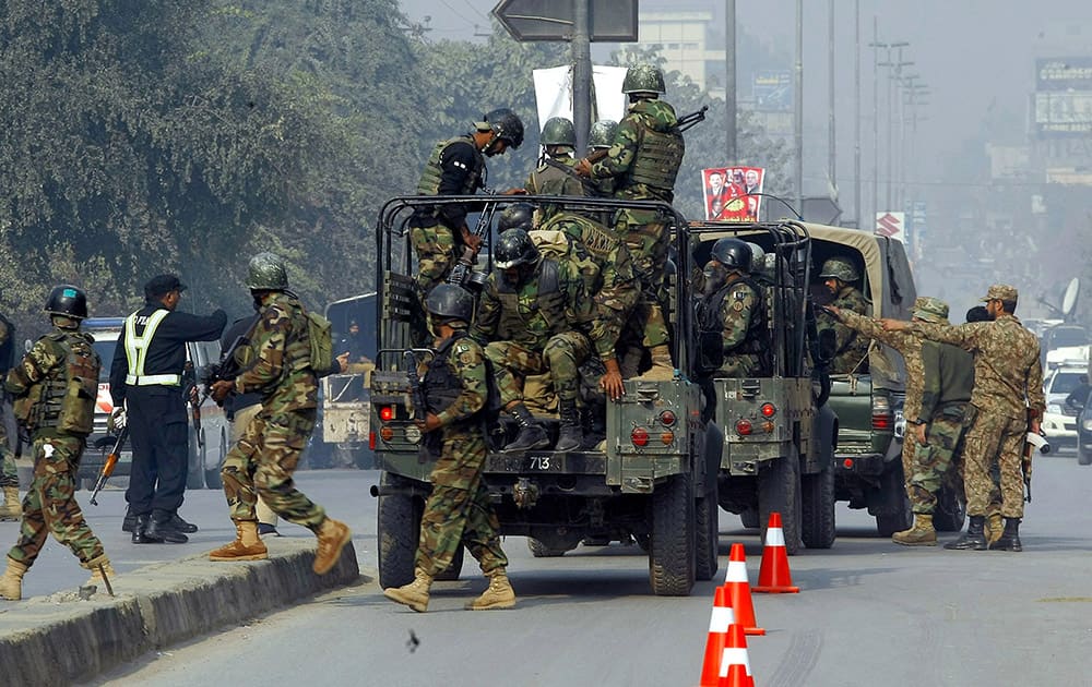 Pakistani army troops arrive to conduct an operation at a school under attack by Taliban gunmen in Peshawar, Pakistan.