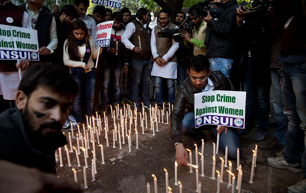 Members of India’s Congress party’s students’ wing hold placards and light candles on the eve of the second anniversary of the deadly gang rape of a student on a bus, in New Delhi, India.