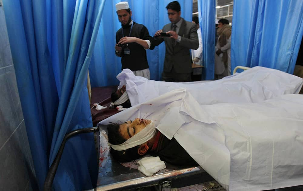 Pakistanis use their mobile phones to take photographs of students who died in a Taliban attack on their school, at a local hospital in Peshawar, Pakistan.