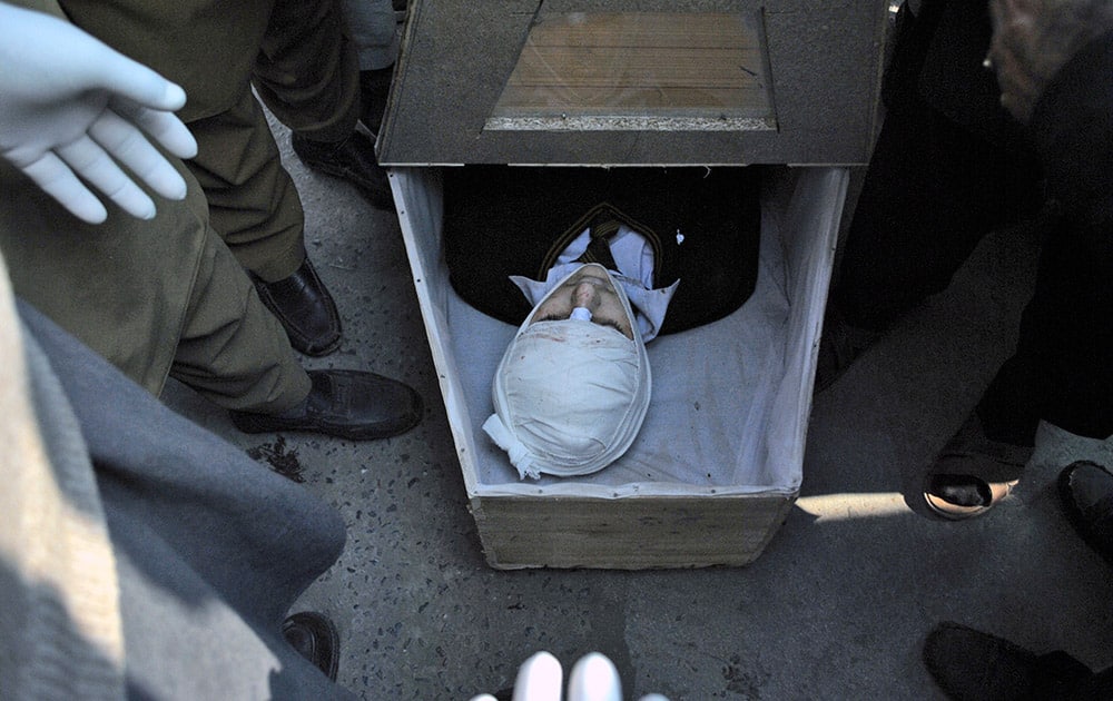 The lifeless body of a Pakistani student, a victim of a Taliban attack in a school, lies in a casket at a local hospital in Peshawar, Pakistan.