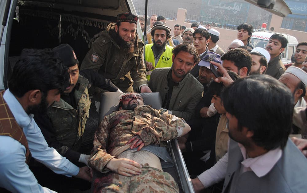 The lifeless body of a Pakistani army officer, a victim of a Taliban attack in a school, is brought to a local hospital in Peshawar, Pakistan.