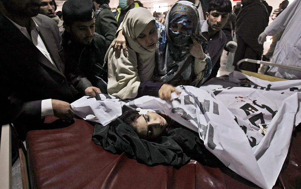 Relatives of a victim of a Taliban attack in a school, mourn over her lifeless body at a hospital in Peshawar, Pakistan.