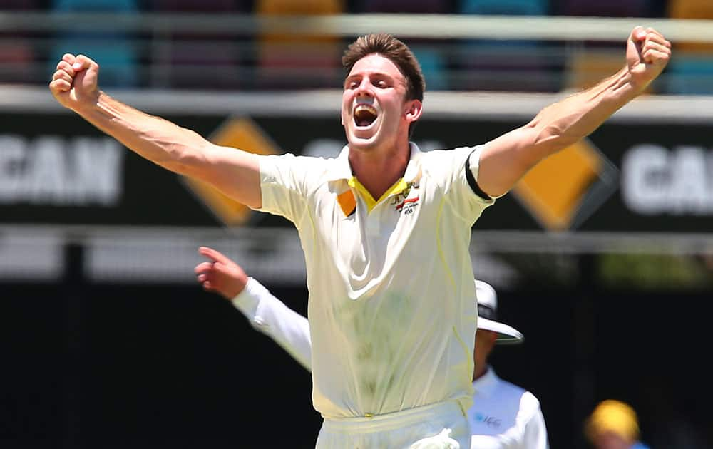 Australia's Mitchell Marsh celebrates after taking the wicket of India's Shikhar Dhawan during the second cricket test match between Australia and India in Brisbane, Australia.