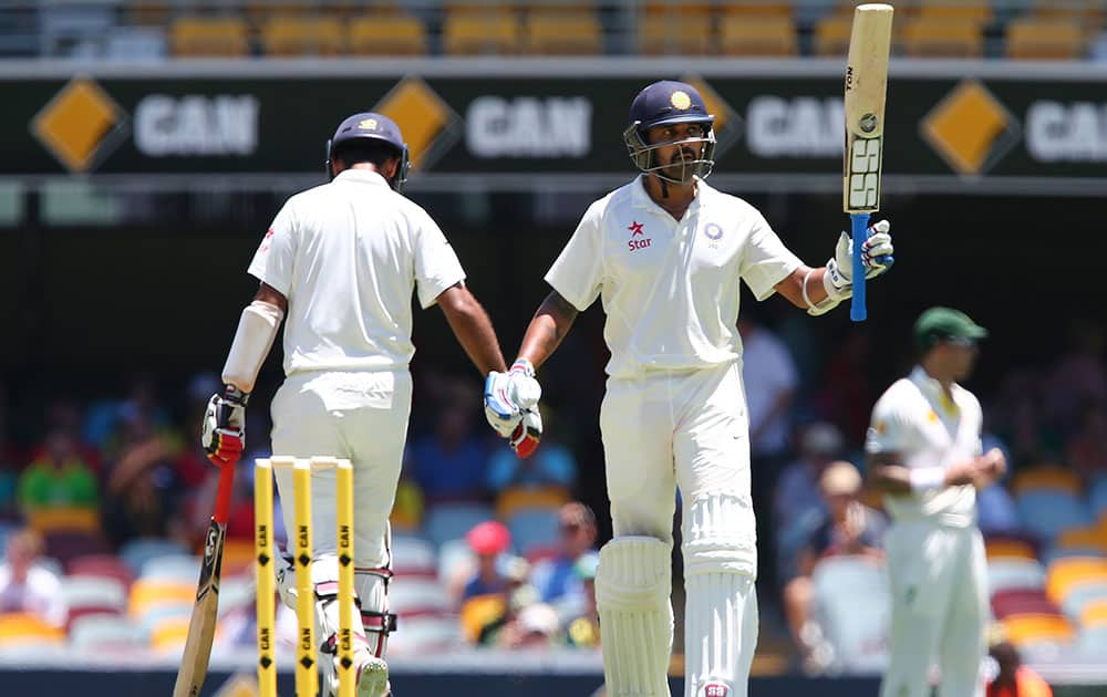 India's Murali Vijay waves his bat after scoring a half century during the second cricket test match against Australia in Brisbane, Australia.