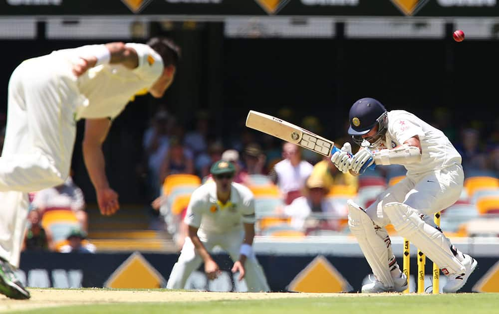 India's Murali Vijay ducks under a bouncer from Australia's Mitchell Johnson, left, during the second cricket test match between Australia and India in Brisbane, Australia.