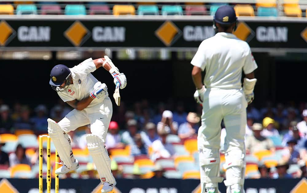 India's Murali Vijay reacts as he avoids a bouncer as his teammate Shikhar Dhawan, right, looks on during the second cricket test match between Australia and India in Brisbane, Australia