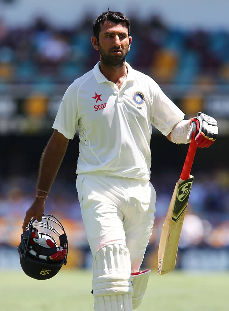 India's Cheteshwar Pujara walks from the field after he was dismissed for 18 runs during play on day one of the second cricket test match against Australia in Brisbane, Australia.