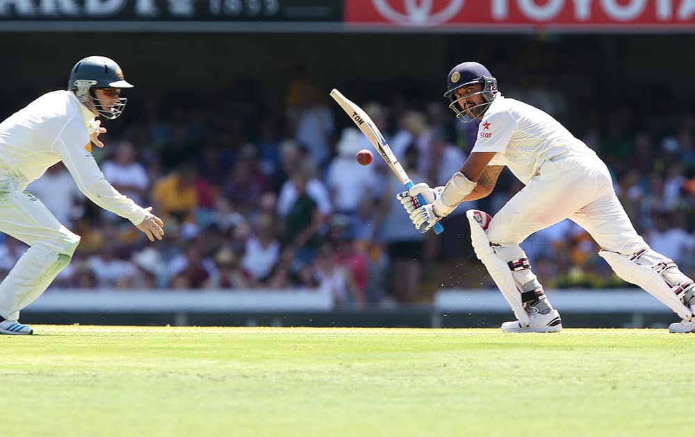 India's Murali Vijay watches his shot as Australia's Chris Rogers moves to to field the ball during the second cricket test match in Brisbane, Australia.