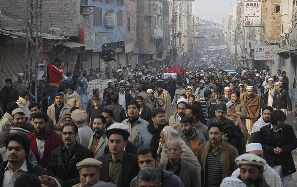 People carry a body of a student killed in Tuesday's Taliban attack on a school in Peshawar, Pakistan.