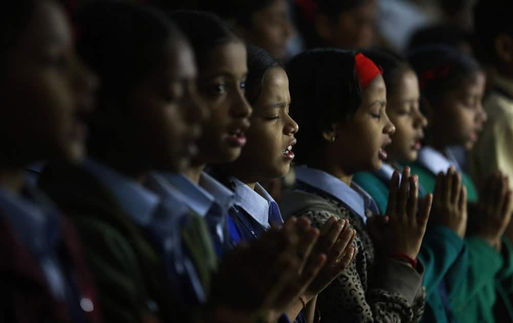 India schoolgirls offer prayers for victims killed in a Taliban attack on a military-run school in Peshawar, in Mumbai, India.