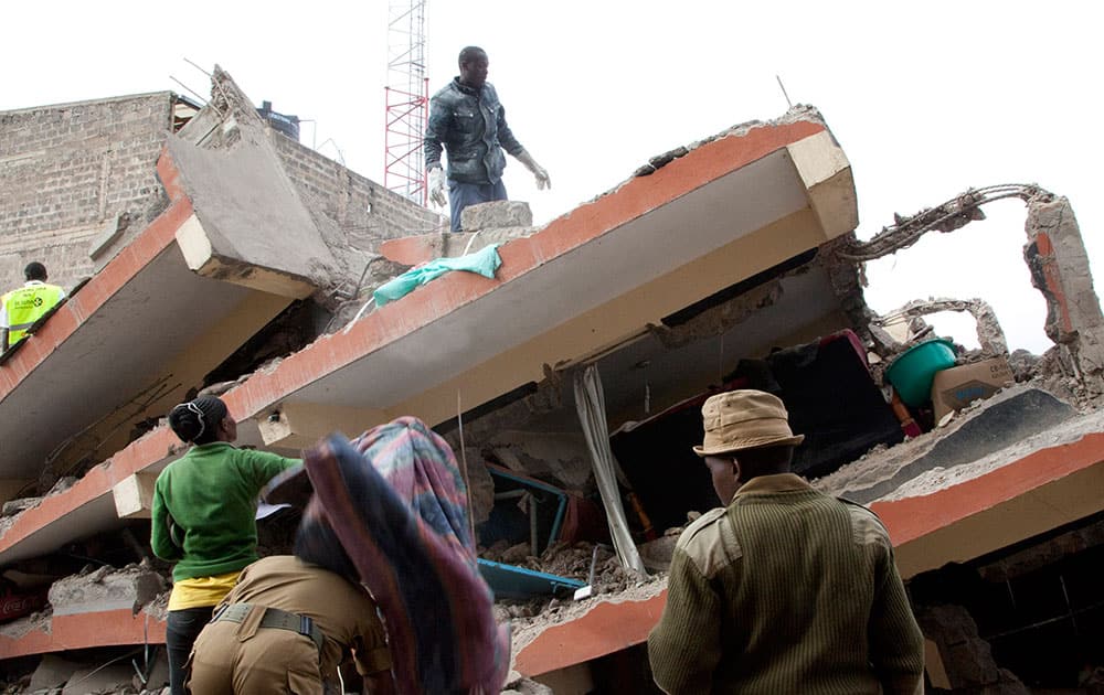 A survivor salvage his belongings atop the collapsed building in downtown Nairobi, Kenya. The five storey residential building had a sixth floor that was in the process of being built, according to a survivor at the scene, and the Kenyan Red Cross tweeted that seven people had so far been rescued from the building with four being referred to a nearby hospital.