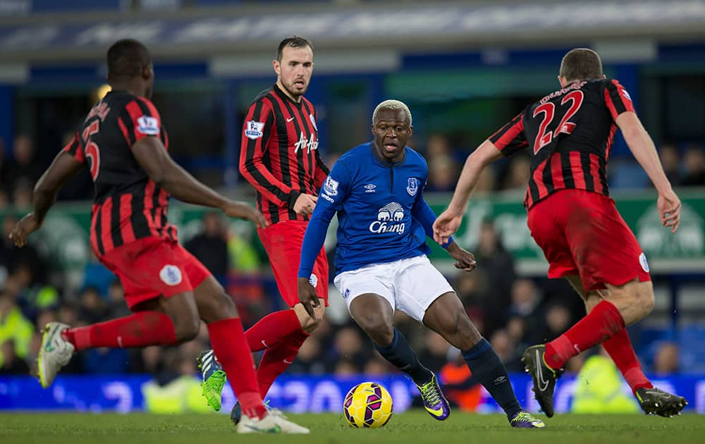 Everton's Arouna Kone, center right, attempts to take the ball past the Queens Park Rangers players including Richard Dunne, right, during the English Premier League soccer match between Everton and Queens Park Rangers at Goodison Park Stadium, Liverpool, England.