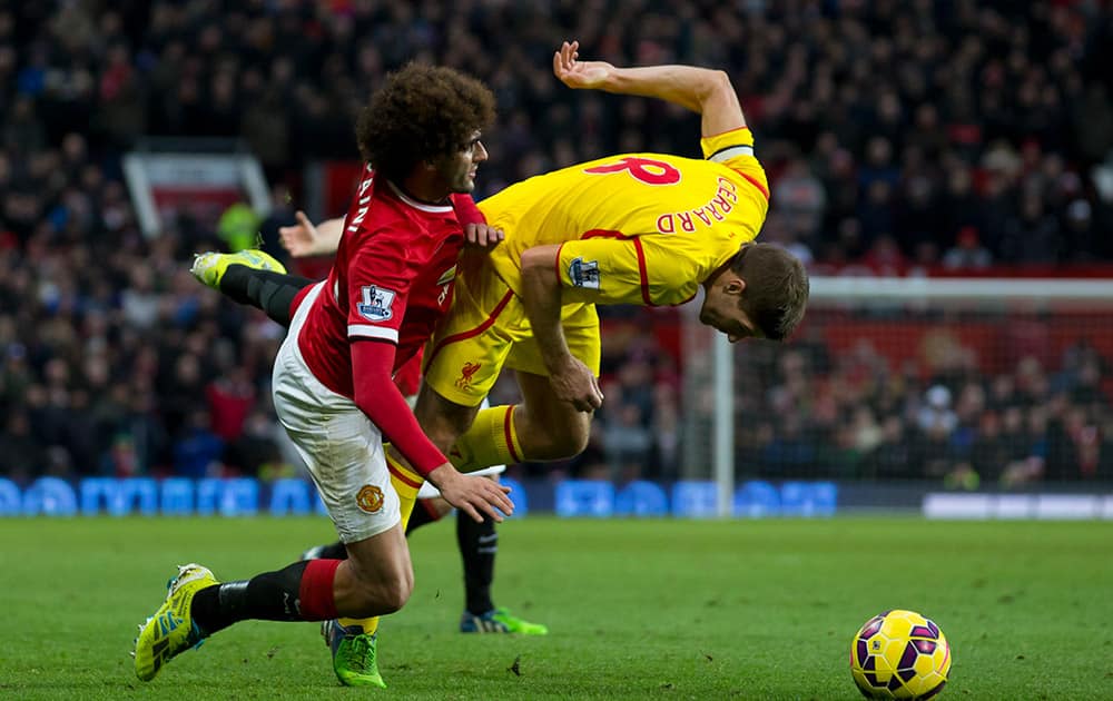 Manchester United's Marouane Fellaini, left, fights for the ball against Liverpool's Steven Gerrard during the English Premier League soccer match between Manchester United and Liverpool at Old Trafford Stadium, Manchester, England.