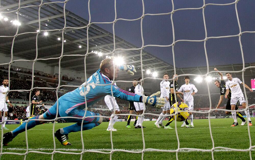 Tottenham Hotspur's Harry Kane, second right, scores their first goal of the game with a header during their English Premier League soccer match at the Liberty Stadium, Swansea.