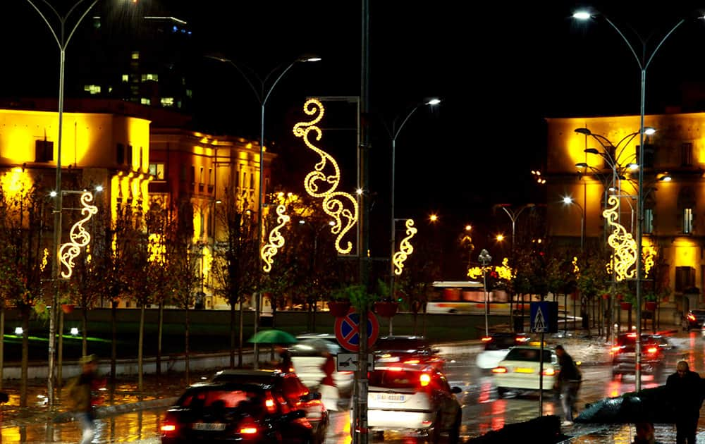 Pedestrians cross the road at Albania's capital main Skanderbeg Square decorated ahead of the Christmas and New Year festivities, both considered as the most popular holidays in the post-communist country, in Tirana, Albania.