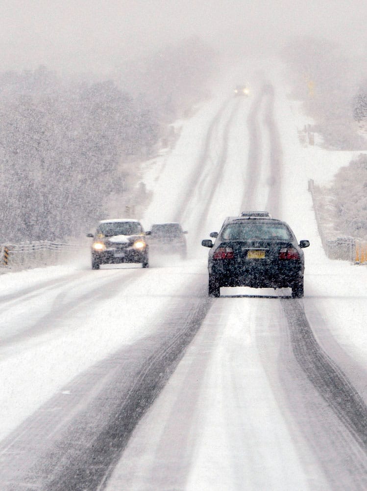 Motorists make their way southbound on the snow covered Old Santa Fe Trail near Santa Fe, N.M. during a snowstorm.