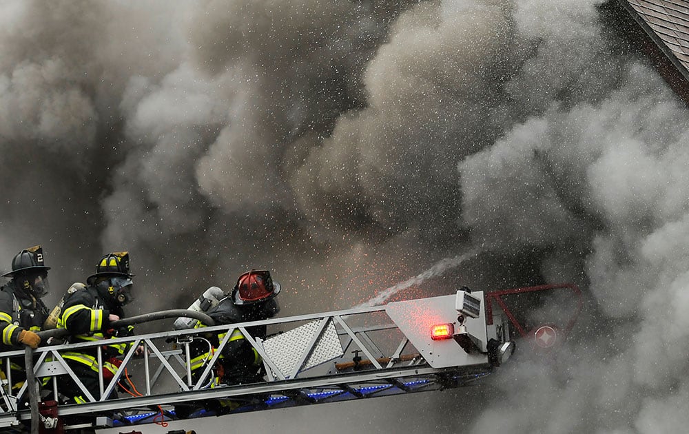 Firefighters battle dense smoke at a house fire in Dickson City, Pa.  Flames ripped through the two-story home, as the heat melted the siding of homes on either side of the fire. The house was destroyed. According to the The Scranton Times & Tribune, no injuries were reported.