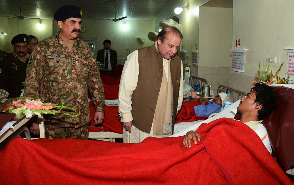 Pakistans Prime Minister Nawaz Sharif, center, talks to an injured student, a victim of Tuesdays school attack, as Army Chief Gen. Raheel Sharif watches them during their visit to a military hospital in Peshawar.