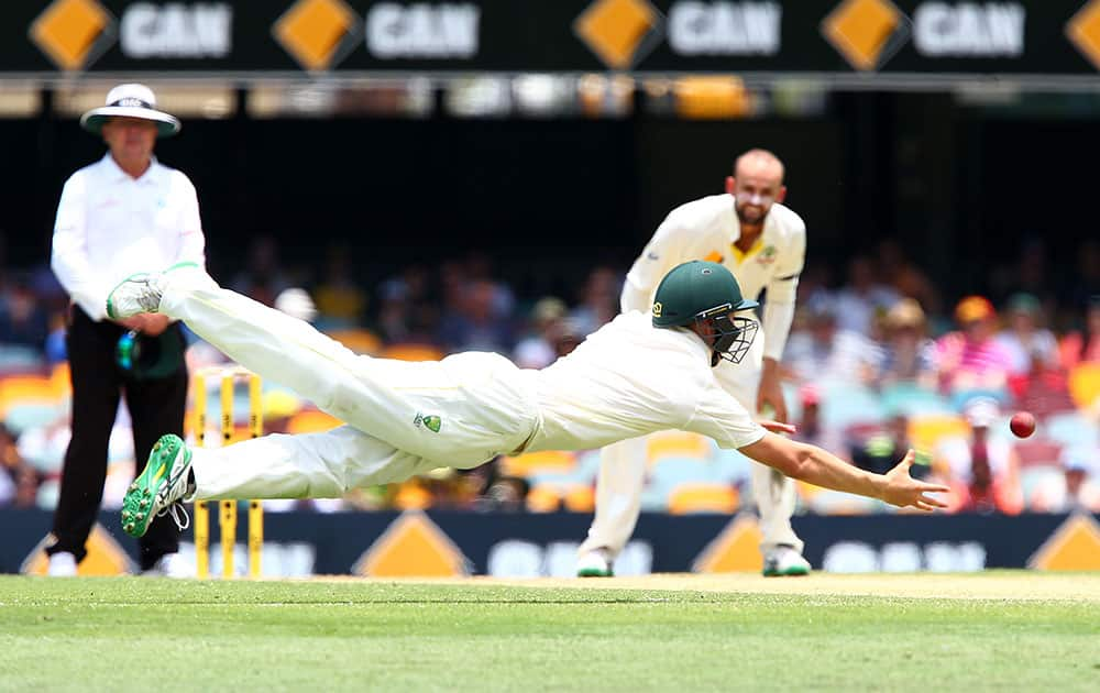 Replacement fielder Marnus Labuschagne is airborne as dives to take a catch to dismiss India's Varun Aaron during play on day two of the second cricket test in Brisbane, Australia.