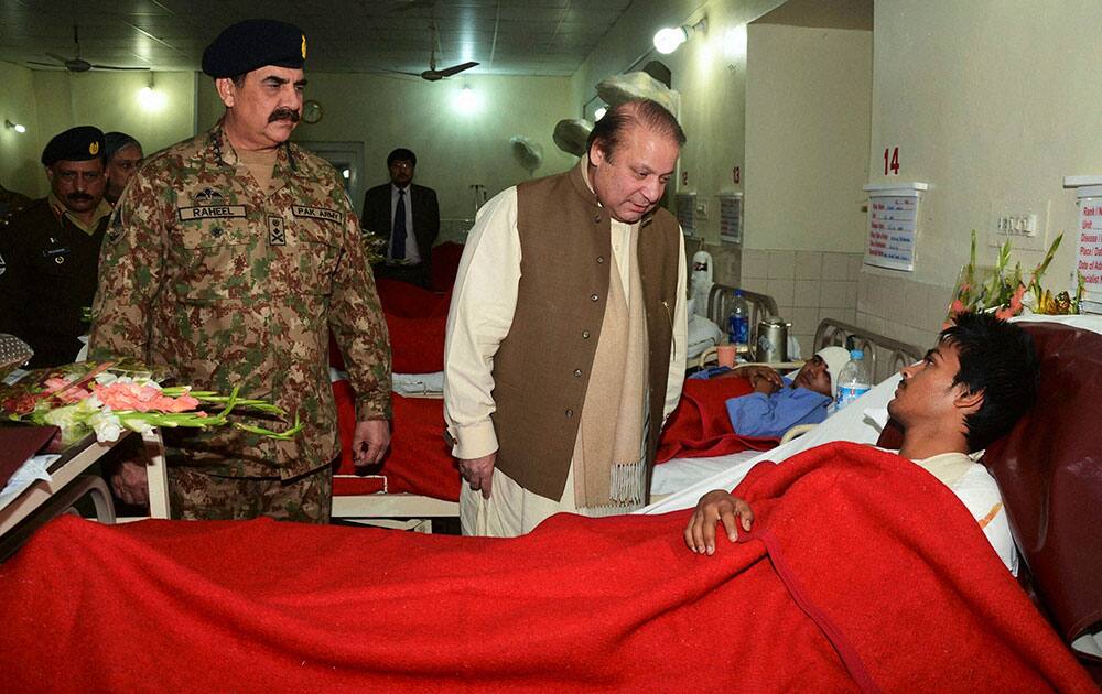 PAKISTANS PRIME MINISTER NAWAZ SHARIF, CENTER, TALKS TO AN INJURED STUDENT, A VICTIM OF TUESDAYS SCHOOL ATTACK, AS ARMY CHIEF GEN. RAHEEL SHARIF WATCHES THEM DURING THEIR VISIT TO A MILITARY HOSPITAL IN PESHAWAR.