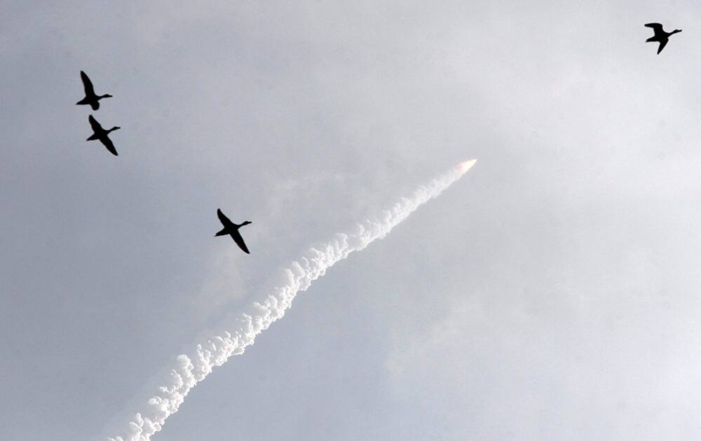 Indian Space Research Organisation’s Geosynchronous Satellite Launch Vehicle (GSLV Mark-III) rocket shoots skyward carrying CARE (Crew Module Atmospheeric Re-entry Experiment), past a flock of geese, from the east coast island of Sriharikota.