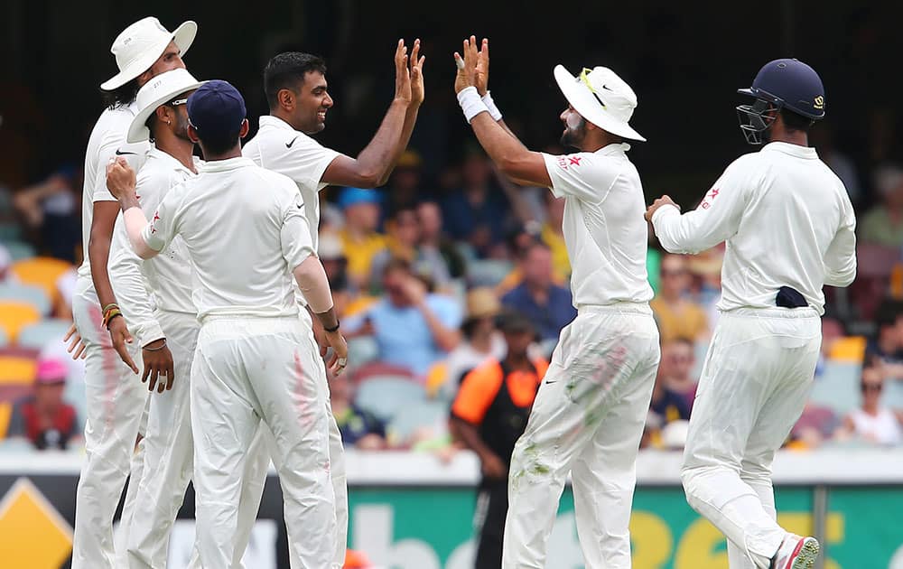 Ravichandran Ashwin is congratulated by teammates after taking the wick of Australia's Shane Watson during play on day two of the second cricket test in Brisbane, Australia.