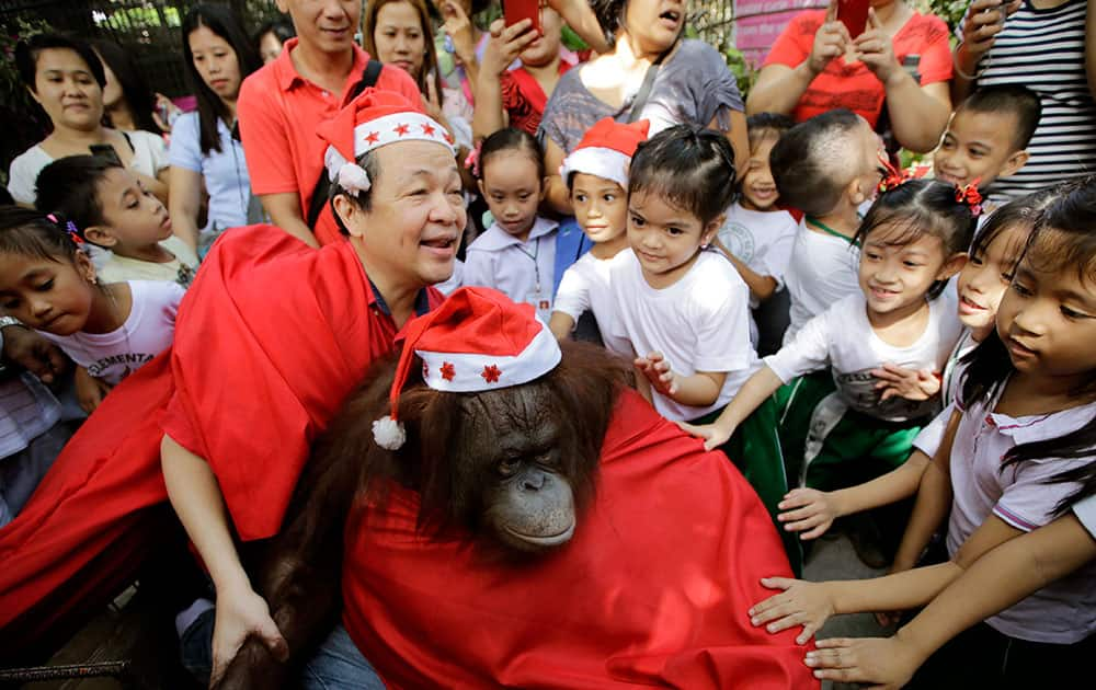 School children touch an orangutan named 