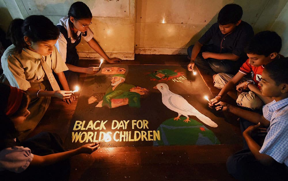 School children make a rangoli with a message condemning the Pakistani Talibans terror attack on children, in Mumbai.