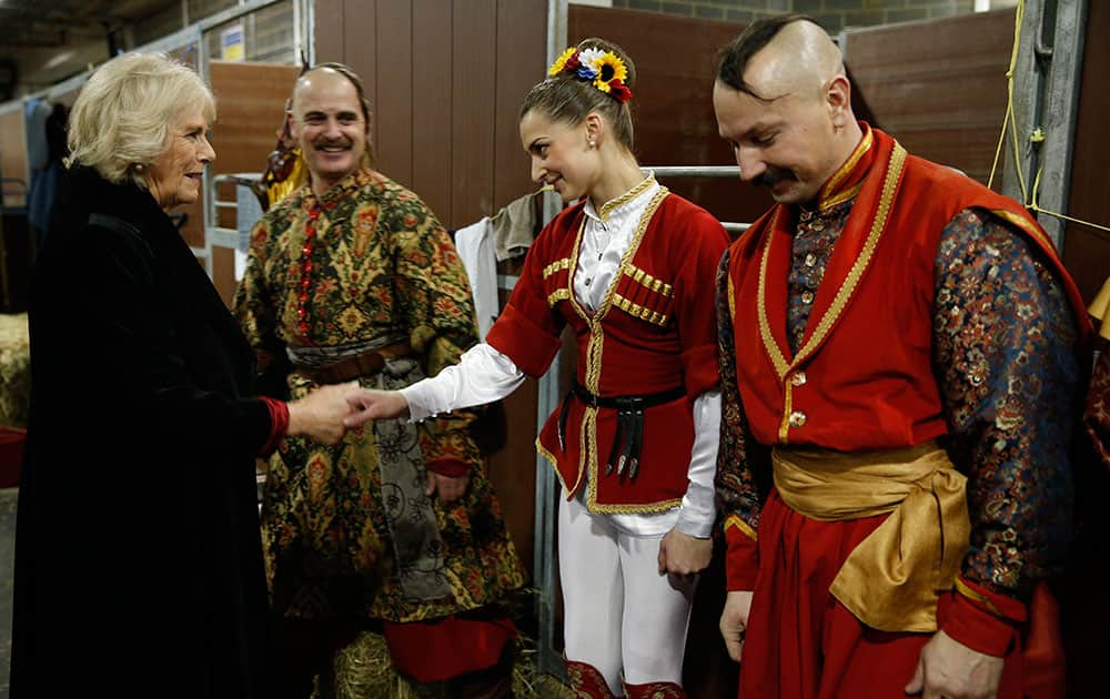 Camilla, Duchess of Cornwall, greets members of the Ukrainian Cossacks, an acrobatic display team, backstage at the Horse of the Year show in London.