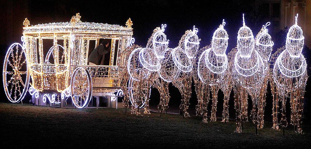 People walk near illuminated Christmas decorations at the Wilanow Palace in Warsaw, Poland.