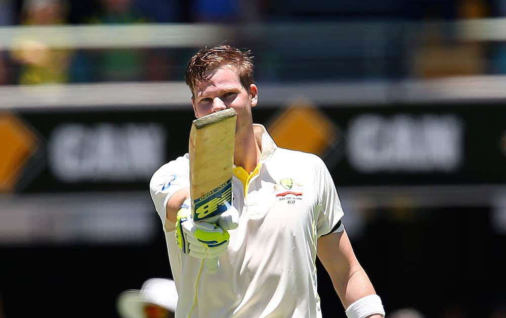 Steven Smith points his bat after hitting a century on the third day of the second cricket test against India in Brisbane, Australia.