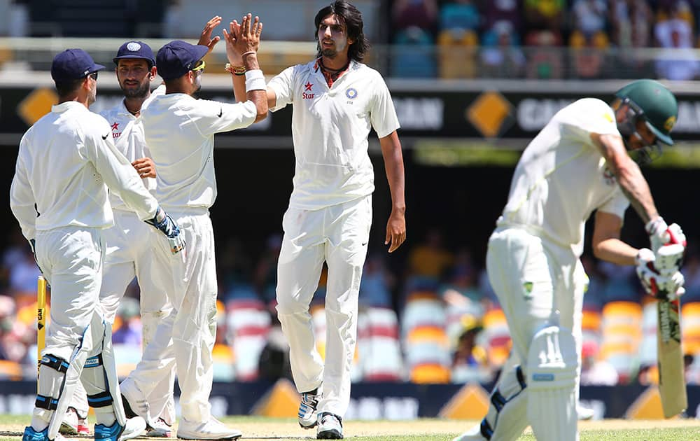 Ishant Sharma celebrates with his team after getting the wicket of Australia's Mitchell Johnson, on the third day of the second cricket test in Brisbane, Australia.