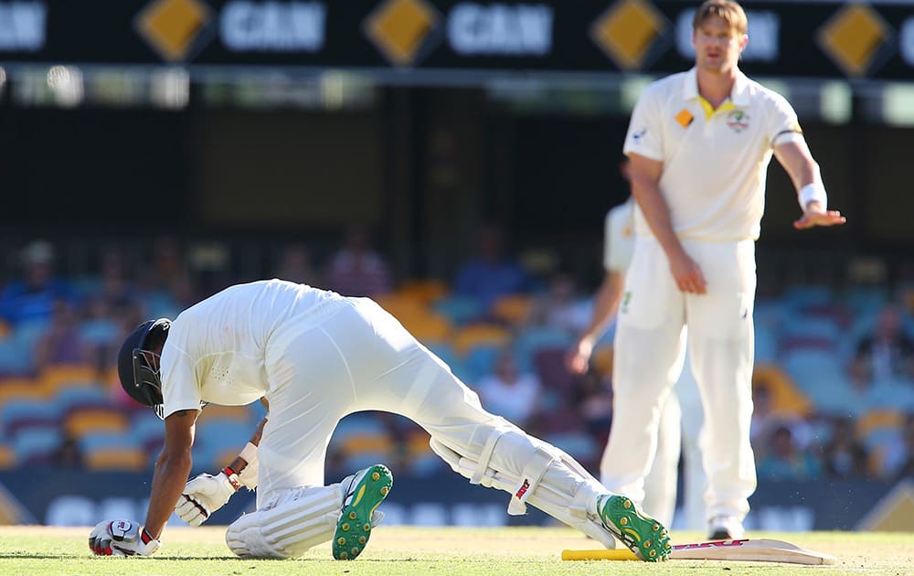 Shikhar Dhawan falls on the ground after he was hit by a ball from Australia's Shane Watson, during day three of the second cricket test between Australia and India in Brisbane, Australia.